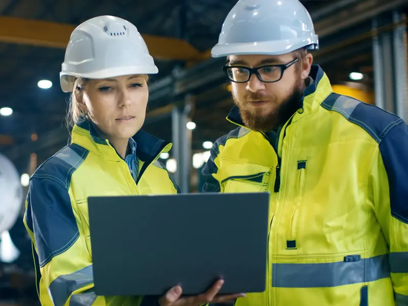Man and woman looking at a computer in a factory